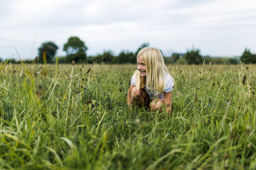 Girl crouching on a meadow - MGOF000503
