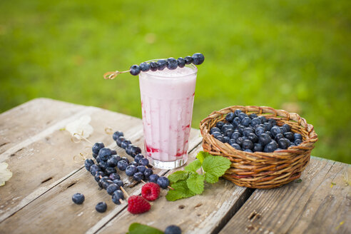 Frischer Himbeermilchshake im Glas, Blaubeeren und Himbeeren - KSWF001555