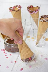Eistüten, Schokolade, Zuckerherzen, Tüte von Hand in Kokosflocken tauchen - YFF000450