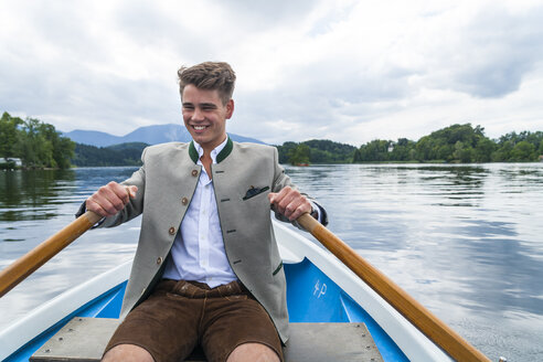 Deutschland, Bayern, Porträt eines lächelnden jungen Mannes beim Rudern auf dem Staffelsee - TCF004851