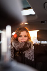 Lächelnde Frau auf dem Rücksitz eines Autos - PESF000142