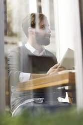 Junger Mann mit digitalem Tablet im Restaurant - PESF000149