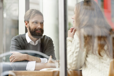 Smiling young man looking at woman in restaurant - PESF000177