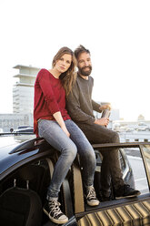 Junges Paar auf dem Autodach sitzend - PESF000171