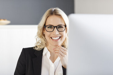 Porträt einer lächelnden blonden Frau im Büro - PESF000046