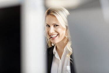 Porträt einer lächelnden blonden Frau im Büro - PESF000048