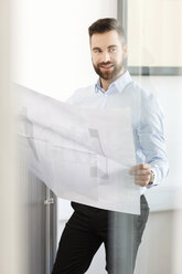 Man in office holding construction plan - PESF000121