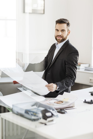 Mann im Büro mit Bauplan, lizenzfreies Stockfoto