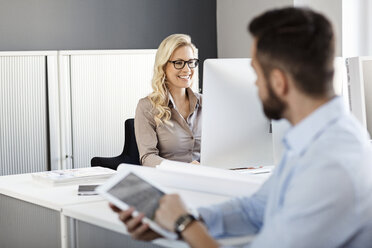 Zwei Kollegen im Büro mit digitalem Tablet und Computer - PESF000063