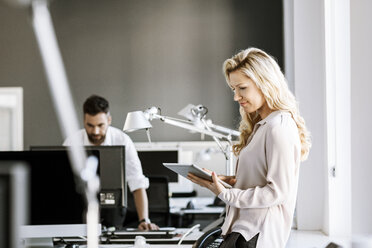 Zwei Kollegen im Büro mit digitalem Tablet und Computer - PESF000066