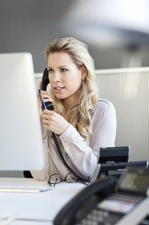 Blond woman in office on the phone - PESF000074