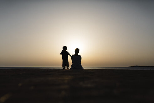 Spanien, Menorca, Silhouette von Mutter und Sohn beim Betrachten des Sonnenuntergangs am Meer - JRFF000009