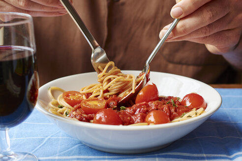 Man eating spaghetti with tomato sauce, close-up - HAWF000842