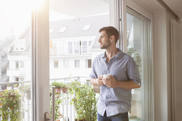 Ernster Mann schaut aus dem Fenster - RBF003496