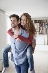 Man carrying woman piggyback at home - RBF003524