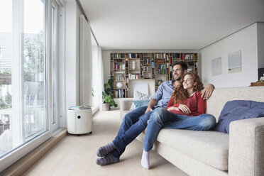 Relaxed couple at home on couch looking out of window - RBF003529