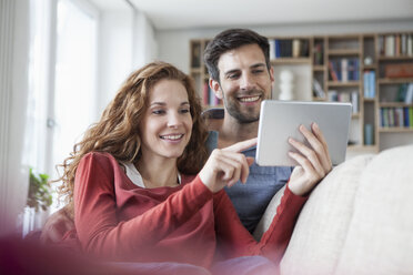 Relaxed couple at home on couch using digital tablet - RBF003535