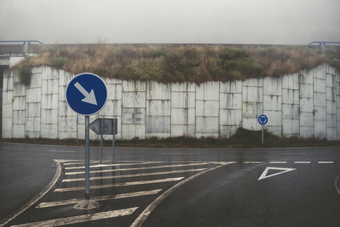 Spanien, Verkehrszeichen auf leerer Straße bei Nebel - RAEF000369