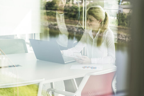 Zwei Geschäftsfrauen im Konferenzraum mit Laptop - UUF005446