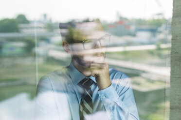 Young businessman looking out of window - UUF005448