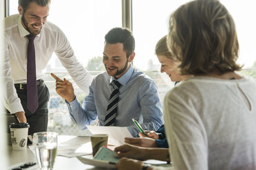 Smiling business people having a meeting in conference room - UUF005496