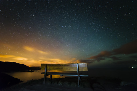 Spain, Ortigueira, Loiba, bench under starry sky with blue ray stock photo