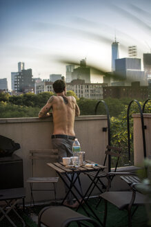 USA, New York City, Mann auf Dachterrasse stehend, Blick - ONF000919