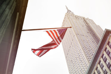 USA, New York City, Empire State Building with American flag in foreground - ONF000877