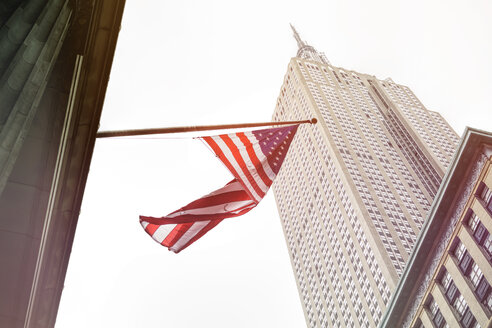 USA, New York City, Empire State Building mit amerikanischer Flagge im Vordergrund - ONF000877