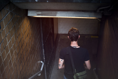 USA, New York City, Mann geht die Stufen einer U-Bahn-Station hinunter, lizenzfreies Stockfoto