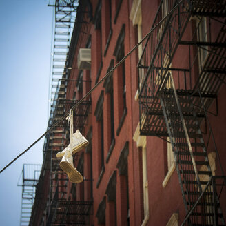 USA, New York City, SoHo, Trainers hanging on electric cable - ONF000907