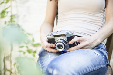 Sitting woman holding camera - FMKYF000627