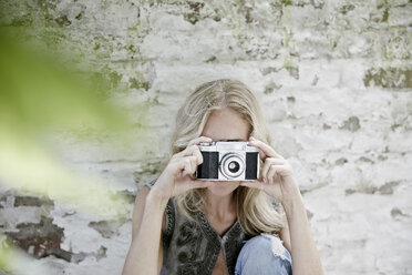 Blond woman taking a photo with an old camera - FMKF002063