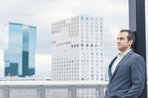 Businessman on urban balcony relaxing after busy day - BZF000215