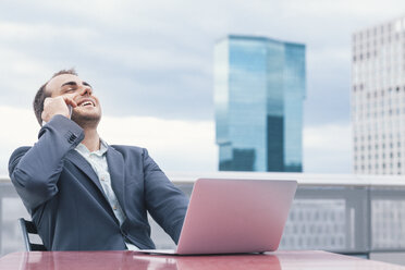 Happy businessman, laughing, Laptop on table - BZF000221
