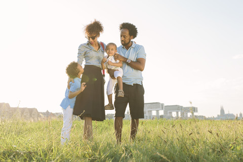 Deutschland, Köln, vierköpfige Familie auf einem Feld, lizenzfreies Stockfoto