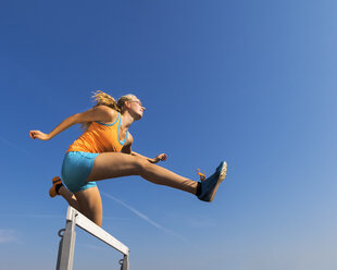 Athlete crossing a hurdle - STSF000859