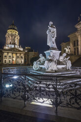 Germany, Berlin, Schiller monument at Gendarmenmarkt with German Cathedral in the background at night - NKF000398