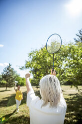 Zwei reife Frauen auf einer Wiese spielen Badminton - RKNF000183