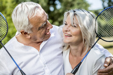 Lächelndes älteres Paar hält Badmintonschläger im Freien - RKNF000191