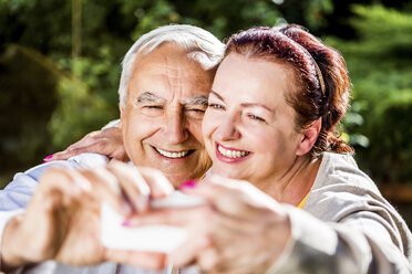 Glückliches älteres Paar macht ein Selfie im Freien - RKNF000263