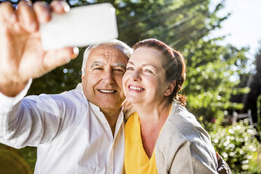 Glückliches älteres Paar macht ein Selfie im Freien - RKNF000265