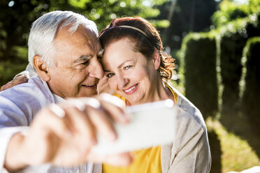 Happy elderly couple taking a selfie outdoors - RKNF000266