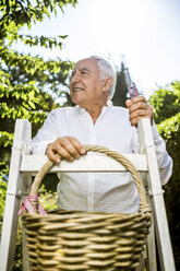 Senior man with basket and ladder in garden - RKNF000278