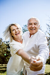 Happy elderly couple dancing outdoors - RKNF000353