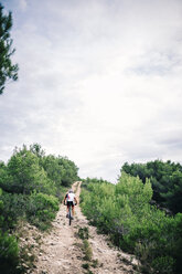 Spain, Tarragona, Mountain biker in extreme terrain, rear view - JRFF000022