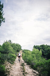 Spanien, Tarragona, Mountainbiker im extremen Gelände, Rückansicht - JRFF000022