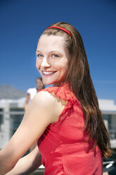 Porträt einer lächelnden jungen Frau im Sonnenschein - TOYF001334