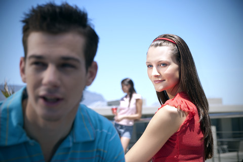 Lächelnde junge Frau mit Freunden im Freien, lizenzfreies Stockfoto