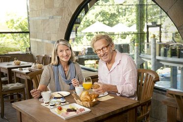 Lächelndes älteres Paar beim Frühstück in einem Cafe - TOYF001259
